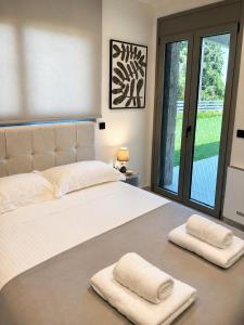 a bedroom with a large bed with two towels on it at Elysian View Lefkakia in Nafplio +35 photos