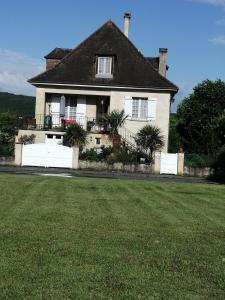 a house with a large grass field in front of it at Pause Périgord in Saint-Cyprien