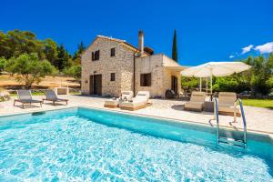 a villa with a pool in front of a house at Villa Boscheto Pente in Agios Leon