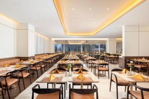 a dining room filled with tables and chairs at Atria Hotel Malang in Malang