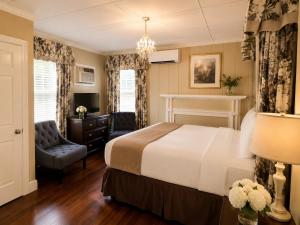 a hotel room with a bed and a chair at Bellevue Manor in Newport