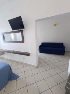 ein Wohnzimmer mit einem blauen Sofa und einem Spiegel in der Unterkunft Tuareg Hotel in Campomarino