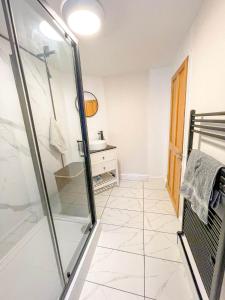a bathroom with a glass shower and a sink at Charming 1-Bed on High St in Longwell Green +1 photo