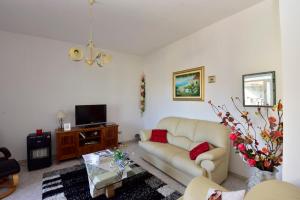 a living room with a couch and a tv at Appartamento Vacanza in Mògoro