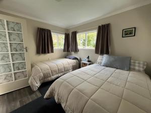 a bedroom with two beds and a window at Destination Cliff Top - Cottage and Homestead in Ohingaiti