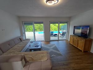 a living room with a couch and a flat screen tv at Villa Una Verde in Bosanska Krupa