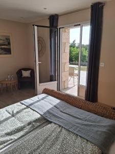 a bedroom with a large bed and a sliding glass door at Les Marchettes in Saint-Nexans +28 photos