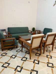 a living room with several chairs and a couch at Colonel Cottage in Prayagraj