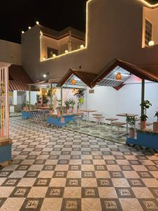 a restaurant with tables and chairs and a tiled floor at Colonel Cottage in Prayagraj