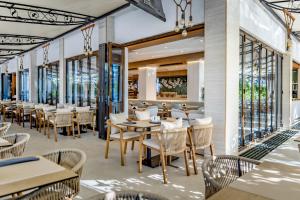 a restaurant with tables and chairs and windows at ELIA MARe Hotel ALL Inclusive - Free Beach Access in Kiten