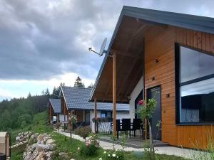 a wooden house with a porch and a balcony at Sunnyside apartments-Pale, Ravna Planina, pool & jacuzzi in Pale