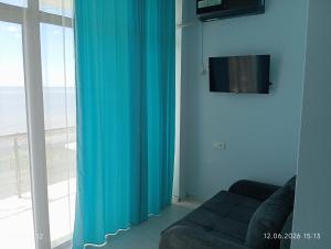 a living room with a blue curtain and a couch at Hotel Marina in Shekhvetili