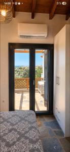 a bedroom with a door open to a balcony at VILLA MIPA Samos in Kámpos