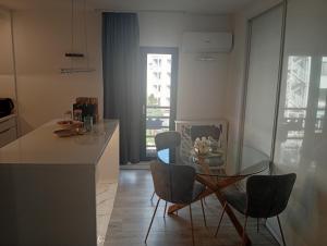 a kitchen with a glass table and chairs at Apartman DALIAROSE Sarajevo in Sarajevo