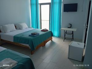 a bedroom with a bed and a table and a television at Hotel Marina in Shekhvetili