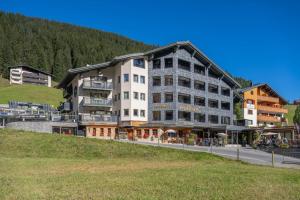 ein großes Gebäude an einer Straßenseite in der Unterkunft Hotel Walliserstube in Damüls