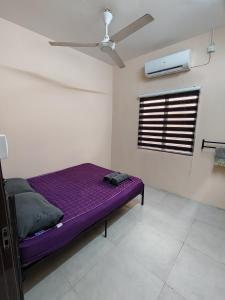 a bedroom with a purple bed and a window at Homestay Che Wan Satu in Kuantan