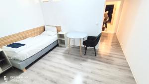 a bedroom with a bed and a table and a chair at Neu-Isenburg in Neu Isenburg +1 photo