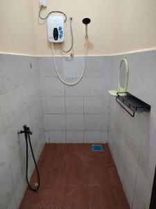 a bathroom with a shower with a mirror on the wall at Homestay Che Wan Satu in Kuantan