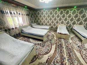 a room with three beds and a rug at Ali guest house in Sary-Mogul
