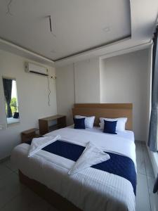 a bedroom with a large bed with blue pillows at VRK Comfort in Mysore
