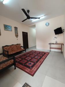 a room with two beds and a rug on the floor at Homestay Che Wan Satu in Kuantan