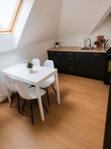 a kitchen with a white table and white chairs at Wynajem pokój kinga Kujawska in Sztutowo