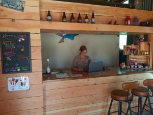 a woman sitting at a bar with a laptop at Estefana in Chambilly