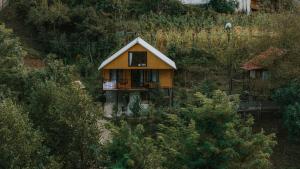 a small house on the side of a hill at River Land Cottages in Tsʼkhmorisi