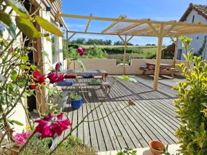 a wooden deck with a picnic table and a pergola at Estefana in Chambilly
