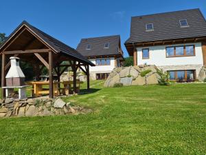 a house with a gazebo and a table in a yard at NowiNowe Domki in Dzianisz