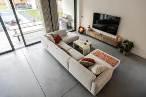a living room with a white couch and a tv at Het Meer in Rotselaar