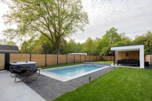 a backyard with a swimming pool and a fence at Het Meer in Rotselaar
