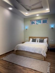 a bedroom with a large bed with white sheets and pillows at The Second Home , Chamba Hills in Chamba