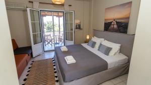 a bedroom with a large bed and a balcony at Fereniki Lemnos Suites in Platy