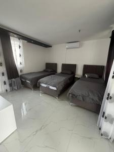 three beds in a room with a tiled floor at Villa Ajša in Bar