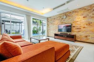 a living room with a couch and a tv at Private pool villa in Kamala Beach