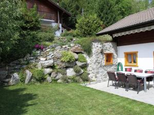 a patio with a table and chairs next to a stone wall at Chalet in Saclentse Basse Nendaz near Ski Area in Nendaz