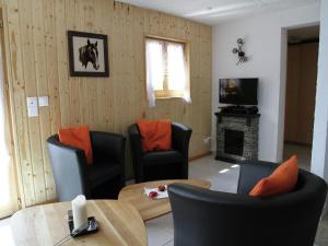 a living room with chairs and a table and a television at Chalet in Saclentse Basse Nendaz near Ski Area in Nendaz