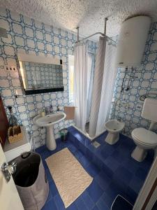 a blue tiled bathroom with a toilet and a sink at Vacation house Dora in Malinska +22 photos