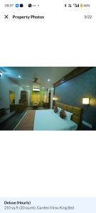 a bedroom with a large bed and a living room at HOTEL The Breeze in Pachamba