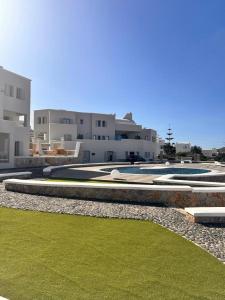 a building with a yard with green grass and buildings at Marvel Suite in Imerovigli