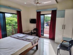 a bedroom with a bed and a balcony at Bliss Paradise Resort in Malvan