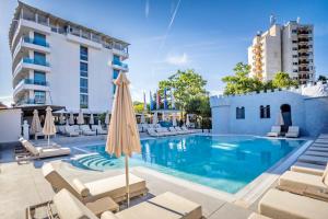 a swimming pool with chairs and umbrellas next to a building at ELIA MARe Hotel ALL Inclusive - Free Beach Access in Kiten