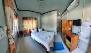 a bedroom with a bed and a television in it at Beyond Pub guest House and Hotel in Ban Tayun