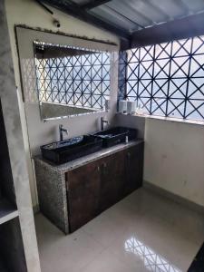 a bathroom with two sinks and a window at Bliss Paradise Resort in Malvan +67 photos