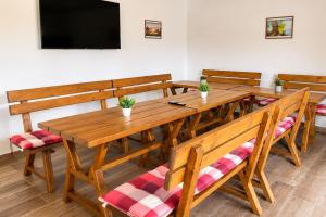 a dining room with a wooden table and benches at Penzion U Kyjovky, Týnec in Týnec