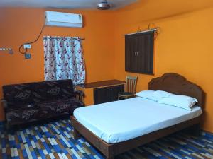 a bedroom with a bed and a couch and a chair at Saimithra Riverview Homestay in Tirunelveli