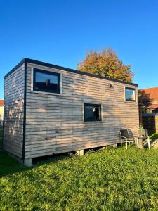 a small house with two windows on a field of grass at Tinyhouse auf der Fischer-Ranch in Westerheim