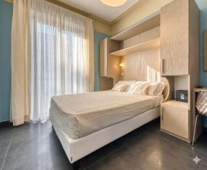 a bedroom with a large bed and a window at Hotel Augustus in Rimini